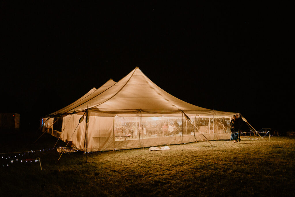 A wedding tent at night with the lights on