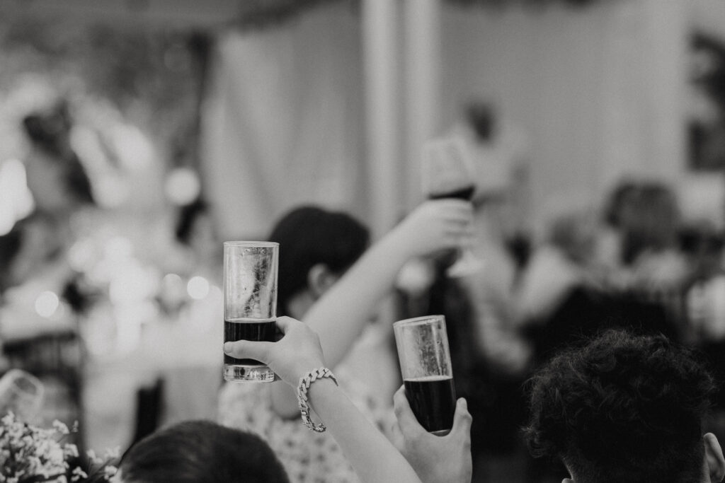 wedding toast with guests raising their glasses to the newlyweds