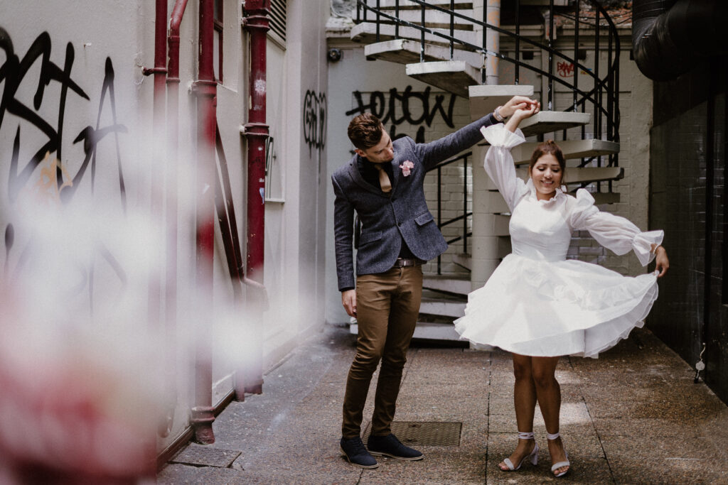 Trendy photoshoot with short wedding dress in the cbd of auckland. Spiral staircase, bus stop and telephone booth in these photos