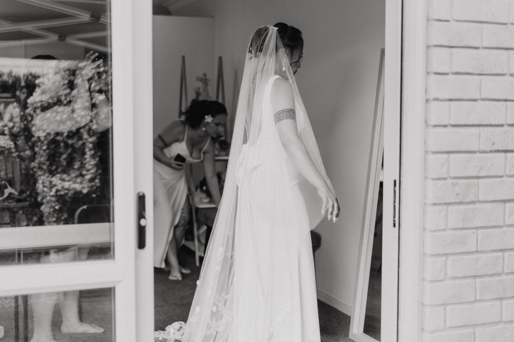 Bride takes a look in the mirror as she prepares for her wedding day in Auckland